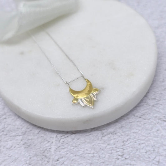 A trinket dish with a sterling silver and gold moon and lotus flower necklace 